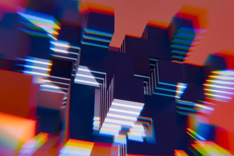 Abstract 3D blocks with glowing edges and colorful light effects appear to float against a blurred reddish background.